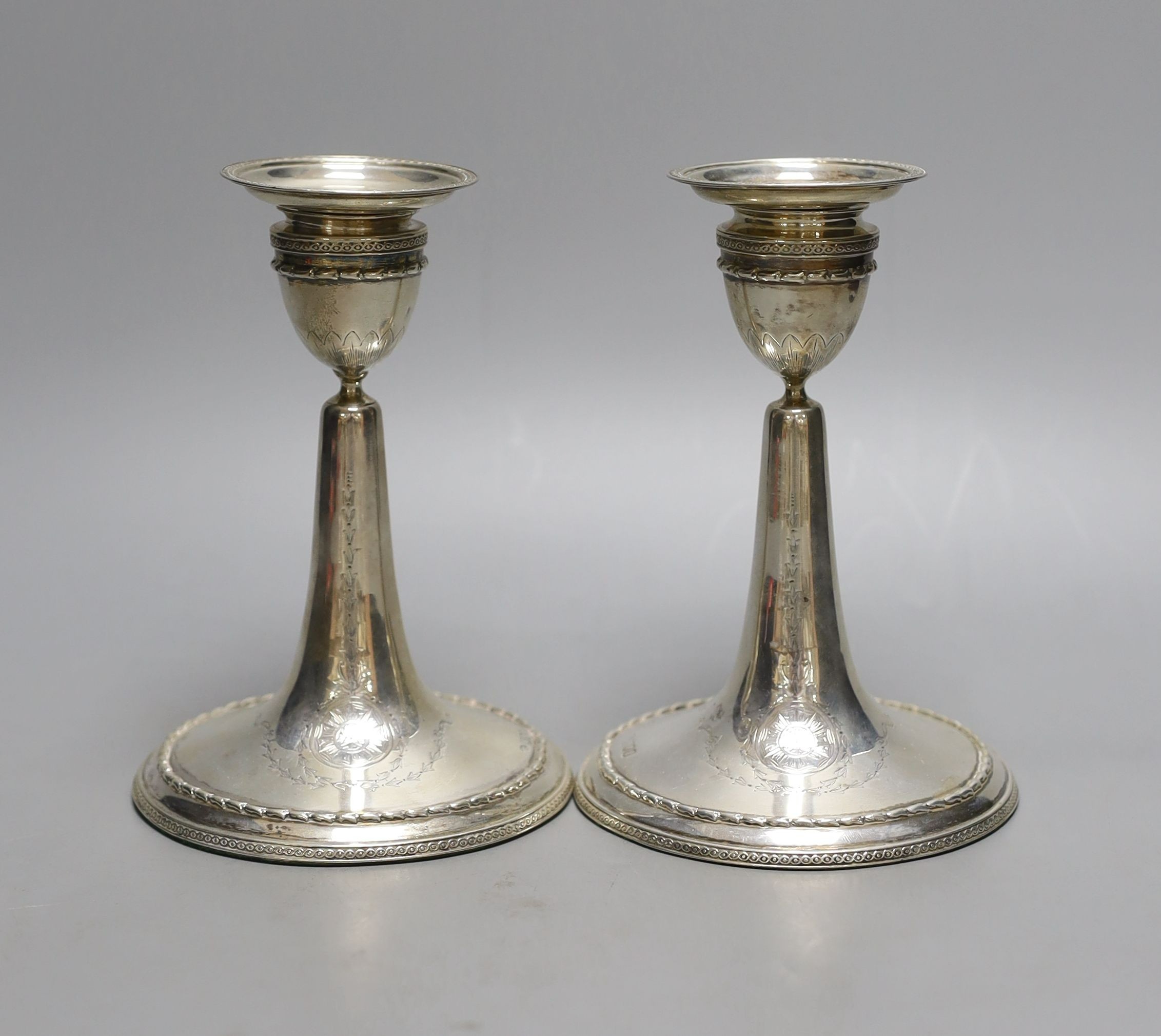 A pair of Edwardian silver mounted dwarf candlesticks, William Comyns, London, 1906, height 14.7cm, weighted.